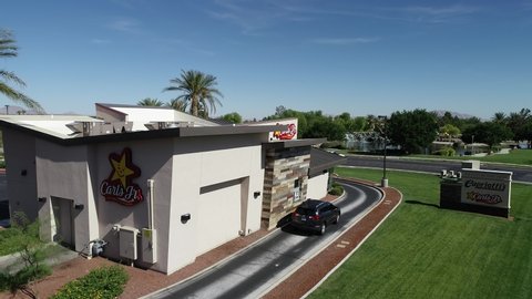 LAS VEGAS, NEVADA- SEPTEMBER 27, 2019: Carls jr. resturant and sign in close by drone flight, black car waiting in the drive throw window, beautiful carl jr facility in the city neighborhood streets.