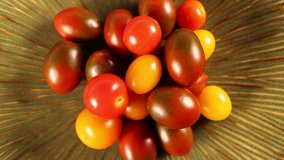 Assorted organic heirloom cherry tomatoes 4k video spinning clockwise slowly top down view