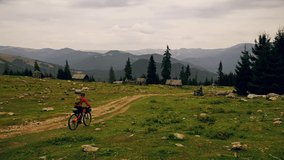 4k drone clip with adventure cyclist riding through an abandoned sheepfold in Maramures mountains, northern Romania