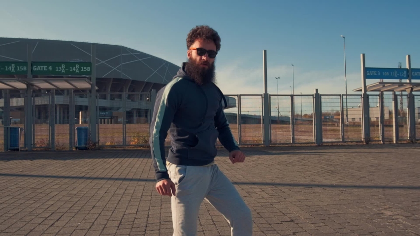 Portrait Hipster Male dancing in street looking to camera,