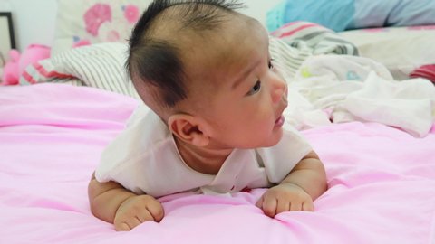 Newborn baby lay prone Was playing on the white mattress, refreshing, in a good mood During bedtime, the child's brain will work. To enhance Memory-boosting and learning-building skills
