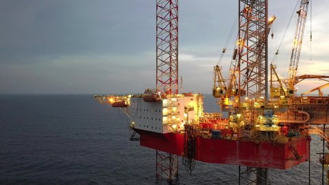 SARAWAK, MALAYSIA - OCTOBER 21, 2019: Standby vessel nearby Velesto Naga 7 offshore jack-up drilling rig and oil production platform in Malaysian Waters with beautiful sunset sky.