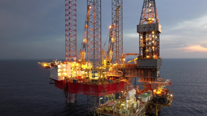 SARAWAK, MALAYSIA - OCTOBER 21, 2019: Standby vessel nearby Velesto Naga 7 offshore jack-up drilling rig and oil production platform in Malaysian Waters with beautiful sunset sky.
