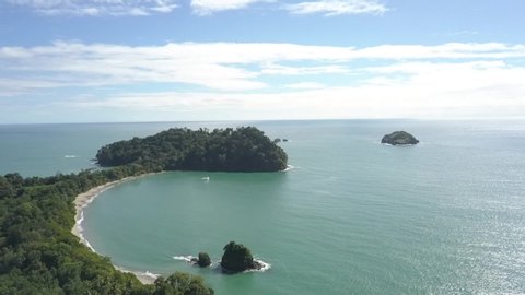 Aerial view of Manuel Antonio National Park in Costa Rica. Drone flies over the tropical sand beach, Cathedral Point, Playa Biesanz.