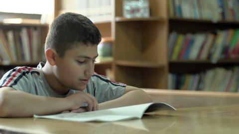 BEIRUT, LEBANON - 2016: A student in 6th grade reads a book at the school's library. Education in Lebanon is compulsory from age 6 to age 14