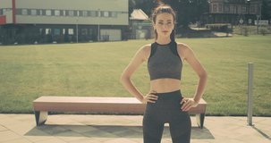 Workout Young woman doing sports in outdoors modern place in city park in summer sunny day under sun light. 4K slow motion video