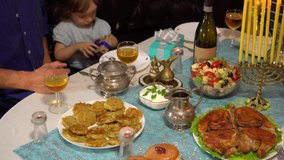 During Hanukkah, many families invite relatives and friends over to light the menorah, sing songs, play dreidel, exchange gifts and enjoy traditional Hanukkah food, especially latkes (potato pancakes) - Powered by Shutterstock - Get 15% off with code: PIKWIZARD15