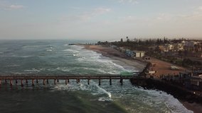 4K aerial drone video of Namibian Atlantic coastline, Swakopmund vintage buildings, town panorama, beach, old Jetty pier, landscape with ocean background of holiday resort at Namibia's west coast