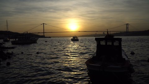 Sunset behind The Bosphorus Bridge at Istanbul, there are little fishing boats too.