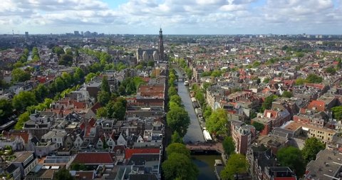 Amsterdam,  Netherlands. Aerial top view of the city centre, surrounded by picturesque houses with red roofs, green trees and canal 