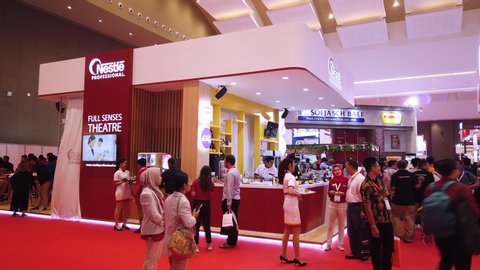 Jakarta / Indonesia - July 24, 2019: Established Shot of Busy Exhibition Booth with Crowded Visitor