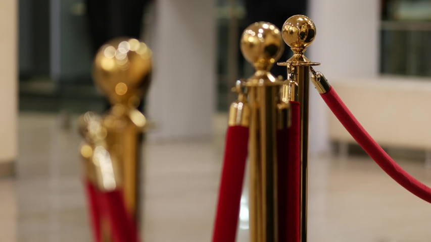 Velvet red ropes closed near valuable exhibit in museum or vip zone at concert or performance. Gold-plated racks with polished balls. Interior barrier for presentation, show, exhibition or display Royalty-Free Stock Footage #1040854685