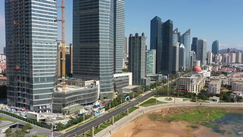QINGDAO, CHINA – SEPTEMBER 2019: Drone flight of modern office towers (some under construction) in central business district in Qingdao, China