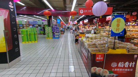 QINGDAO, CHINA – SEPTEMBER 2019: Fast motion GoPro 'time warp' walking through large foreign supermarket (Carrefour) in Qingdao, people doing groceries in Chinese city