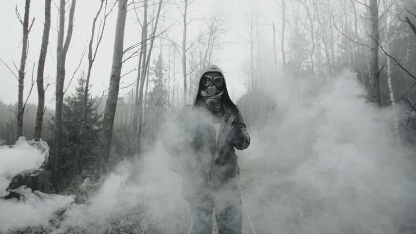 Lonely human in protective gas mask and military clothes walking on old railway in clouds of toxic smoke. Stalker surviving after nuclear or chemical war in empty dead forest. Post apocalyptic world Royalty-Free Stock Footage #1040861834