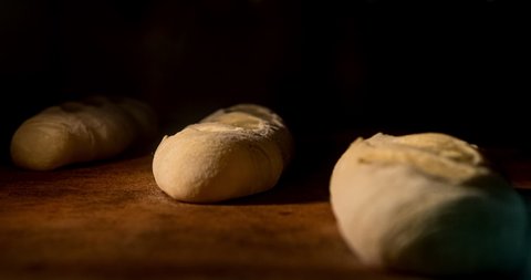 Warm fresh baguette in a bakery. Making bread and eco production. Manufacturing process working hard. Bakery shop and selling rooty. Baking Italian bio bread in oven. Time lapse footage of cooking.
