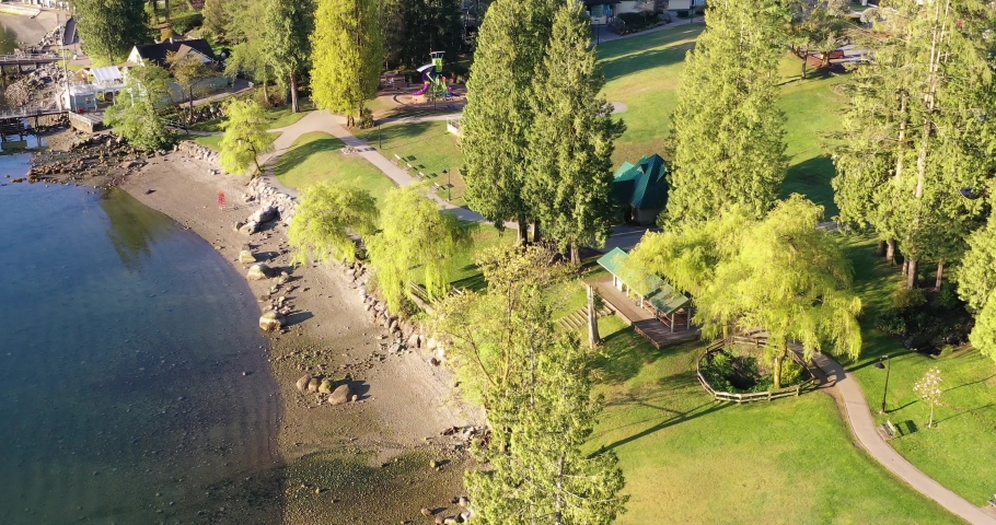 View over inlet, ocean and island with boat and mountains in beautiful British Columbia. Canada. Aerial drone flying. 4K.