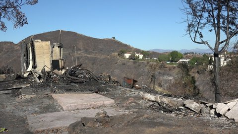 Remains of a house on a burned hill days after a wildfire
