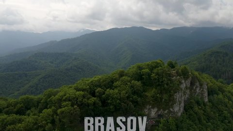 4K Brasov City Hollywood Sign Carpathian Mountains Drone Aerial Romanian Flag