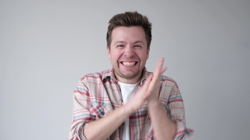 Young man smiling with glee as he rubs his hands together. Great news concept