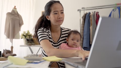portrait of woman with baby working from home of her online ecommerce shop