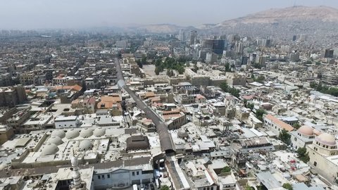 Tilt up from building's rooftops to Umayyad Mosque and Damascus skyline, Syria
