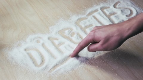 Diabetic hand writes the word diabetes on sugar. The concept of diabetes and metabolic disorders