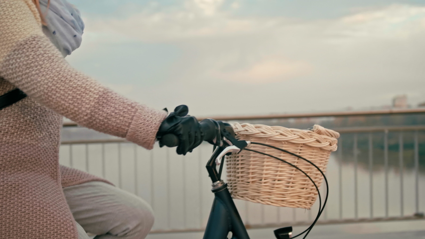 Close up Unrecognizable Business Woman is Riding Bike with Basket in City on Bridge in the Autumn Morning. Urban Cycle Chic and Ecological Transportation. 4K Close up Tracking Shot with Copy Space