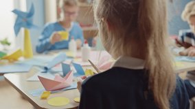 Elementary School Arts & Crafts Class: Diverse Group of Smart Children Have Fun on a Handicraft Project, Using Colorful Paper, Scissors and Glue to Create Fun Papier Mache. Arc Camera Shot - Powered by Shutterstock - Get 15% off with code: PIKWIZARD15