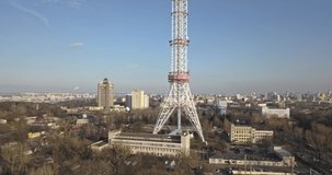 TV tower on the background of the modern city around a blue sky on a sunny day. 4K video, 240fps, 2160p.