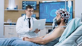Doctor using his laptop in modern facility for brain analysis. Sleeping patient wearing air mask and brainwaves scanning headset. - Powered by Shutterstock - Get 15% off with code: PIKWIZARD15