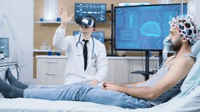 Doctor wearing virtual reality goggles in a modern facility for brain analysis. Patient sitting on bed with brain sensors attached and air maks - Powered by Shutterstock - Get 15% off with code: PIKWIZARD15