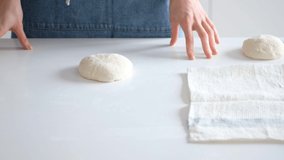 Woman forms balls for bread from raw dough with her own hands. Bread 4K
