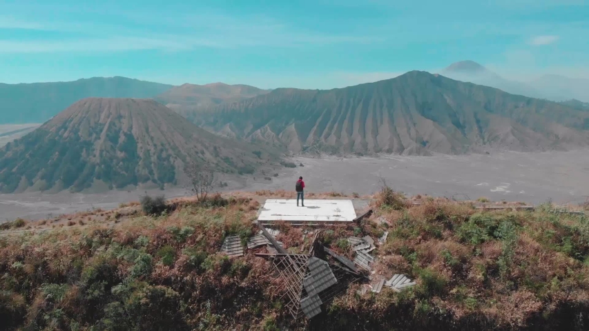 aerial view of Mount Bromo behind a cliff and traveller, Malang east java