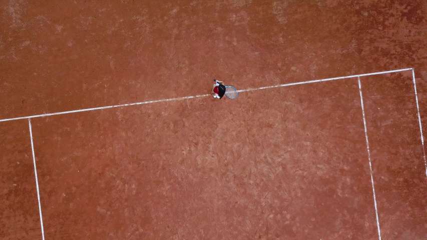 Little girl tennis player stands on the tennis court and turns the torso in different directions