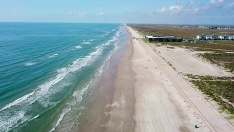 Corpus Christi, Texas  / USA – September 13 2019:  Aerial view by drone, backwards along the shore of the Gulf of Mexico, the waves on a Padre Island beach. 4K resolution. FAA part 107 sUAS certified.