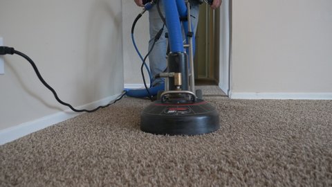 A carpet cleaner finishes cleaning a dirty apartment carpet with a steam cleaner. Watch him demonstrate the steam of the carpet cleaning machine at the end.