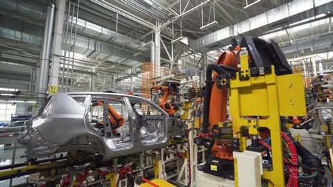 BELARUS, BORISOV - AUGUST 7, 2019: Automobile plant, modern production of cars, transportation of car body on the production line, robots at work, build process.