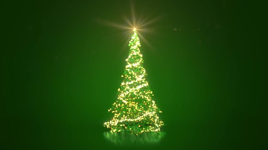 Rotating Christmas tree from glow shiny particles and baubles on green background. Christmas or New Year background with copy space. 
