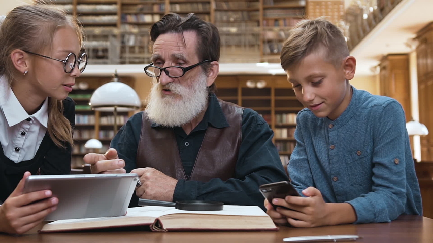 Decisive intelligent bearded senior grandpa putting aside the favourite modern grandchildren