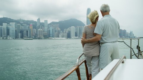 Caucasian couple enjoying retirement sightseeing Victoria Peak skyline city skyscrapers Hong Kong Far East Asia RED MONSTRO