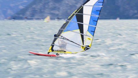 Torbole - Nago, Lago di Garda (Lago Benaco), Italy - July 16, 2019: Windsurfing and paddleboarding on Lake Garda in Torbole resort. Windsurfer Surfing The Wind On Waves, Recreational Water Sports