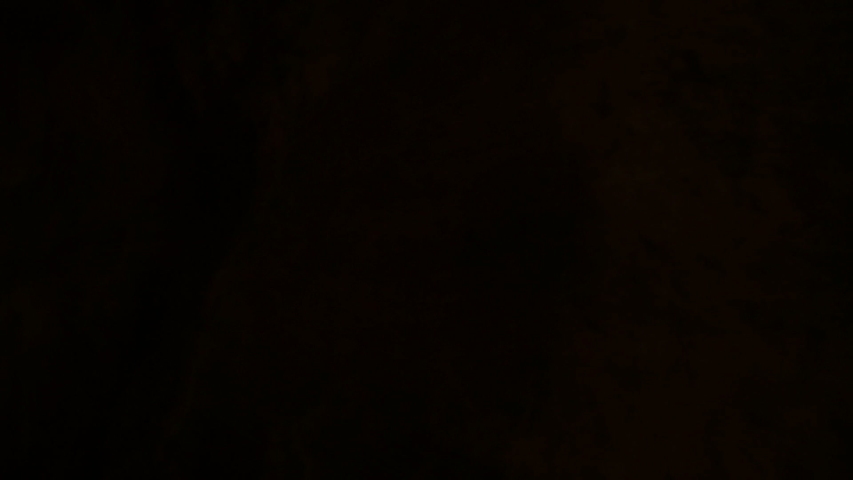 Man enters a dark cave and walk into darkness, slow motion