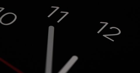 Timelapse or time lapse of clock on black background and movement of clock hands. Royalty high-quality 4k stock video footage time lapse clock with three arrow white hands moving too fast to 12 hours