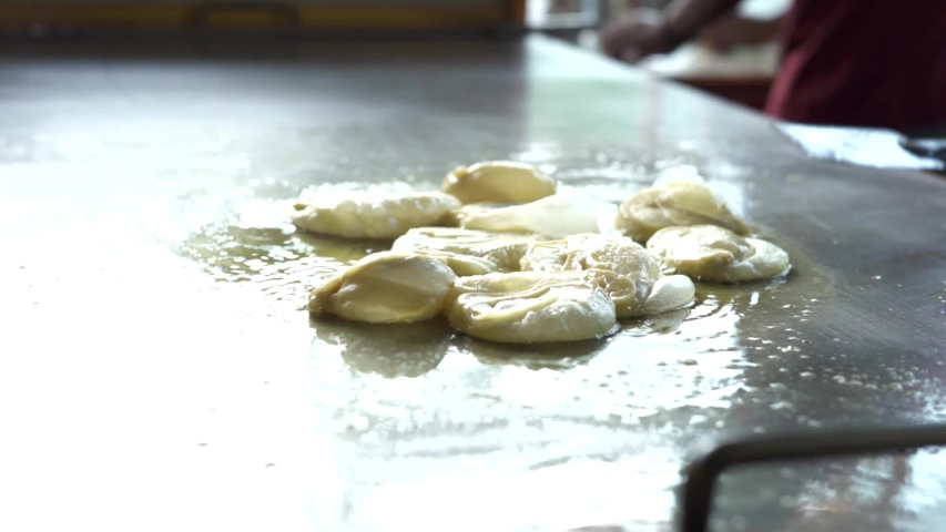 Vendor cooking Roti Canai or chapati, Indian traditional street food