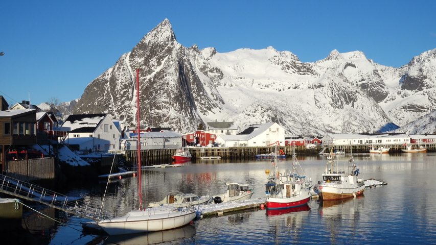 beautiful norwegian winter landscape with the multicolored rorbu and moored fishing ships at the bay of Lofoten archipelago, nothern Norway
