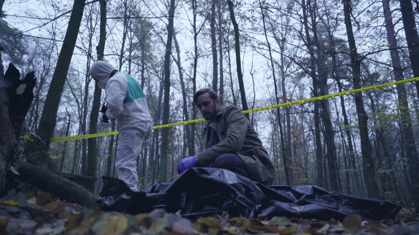 Detective looking at maniac victim body, forensic experts examining crime scene Royalty-Free Stock Footage #1041038138
