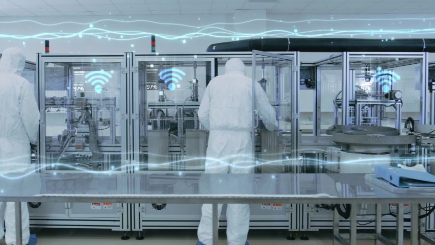 Manufacturing Facility Workers Assembling Products Using Industrial High Precision Machinery. Special Effects Animation: Information Internet Lines and Wi-Fi Connected Icons. Industry 4.0 Concept
