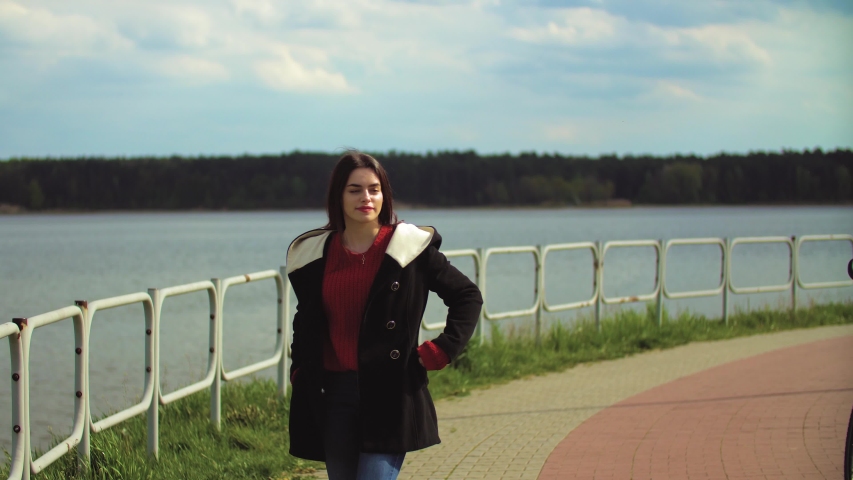 Beautiful young girl is walking by the lake