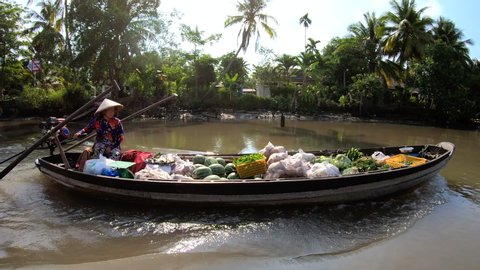 Vietnamese homes and villages served by small floating markets carrying fresh fruit and vegetables in motorized vessels Mekong river Vietnam travel and tourism